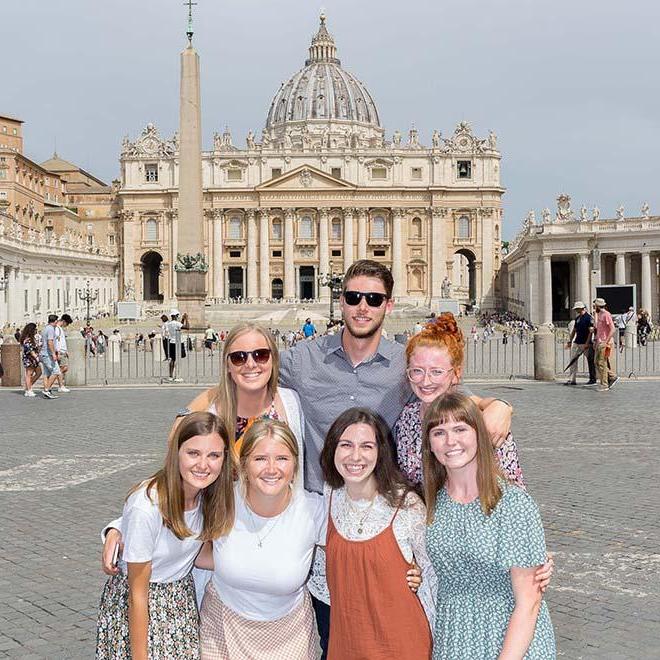 Group of smiling study abroad students in front of St. Peter’s Basilica in Rome